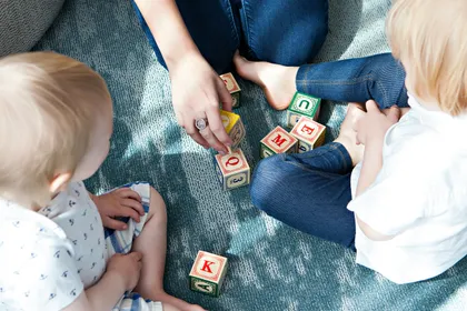 Garde d'enfants jouant avec deux enfants — garde partagée à Grenoble